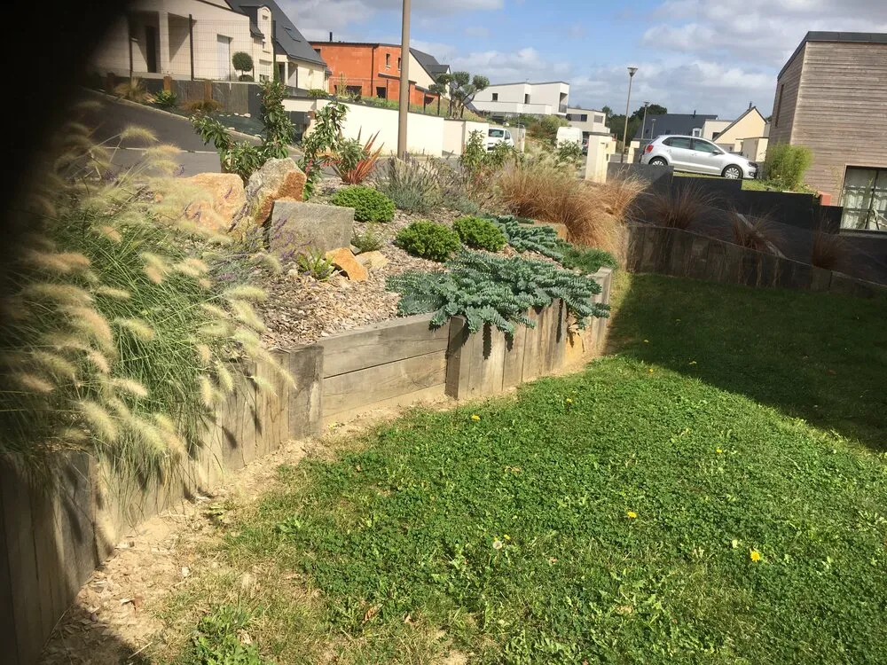 Aménagement d'un massif avec poutres paysagères dans un jardin à Lamballe