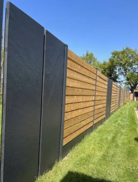 Gros plan sur panneaux ardoise naturelle anthracite d'une clôture mixte bois autoclave et aluminium, vue côté allée avec galets, Lamballe Côtes-d'Armor