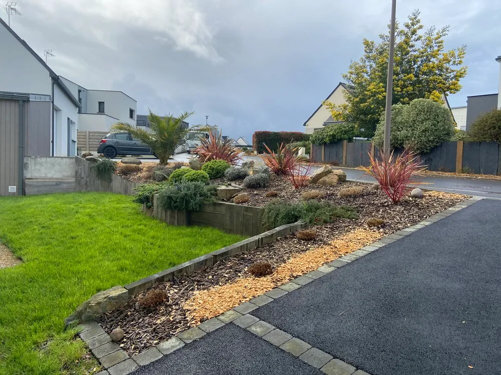 Aménagement d'un parterre de plantation avec paillage de morceaux de bois à Lamballe