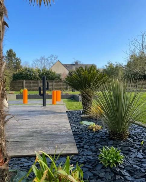 Détail du contraste net entre le paillage d'ardoise noire et les gravillons blancs après un désherbage manuel minutieux.